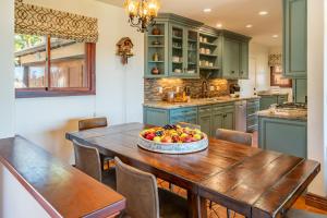 a kitchen with a wooden table with a bowl of fruit on it at Vista Verde by Paradise Retreats in Santa Barbara