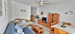 a living room with a blue couch and a table at Apartamento Sabimar Playa in San Luis de Sabinillas