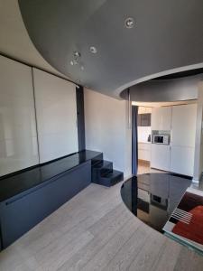 a living room with black and white furniture and a kitchen at Suite Mille in Piacenza