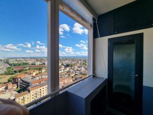 a room with a window with a view of a city at Suite Mille in Piacenza
