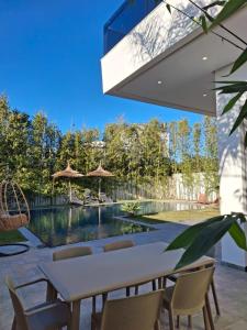 a patio with a table and chairs and a swimming pool at Villa 6chambres Aéroport de Fès Piscine Jacuzzi in Fès