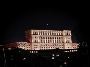 a large building is lit up at night at Parliament View Studio City Center - Pumo Properties in Bucharest