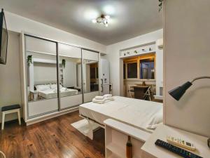 a bedroom with a bed and a desk and a mirror at Parliament View Studio City Center - Pumo Properties in Bucharest