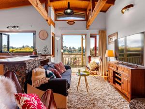 a living room with a couch and a table at Treetop Hideaway - Taupo Holiday Home in Taupo