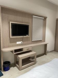 a room with a tv on a wall at HOTEL HERITAGE Inn in Indore