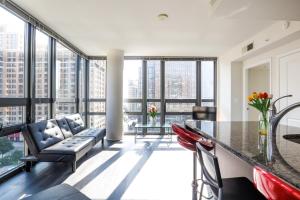 a living room with a table and chairs and large windows at Pentagon Luxe Apartments Arlington - Near DC in Arlington
