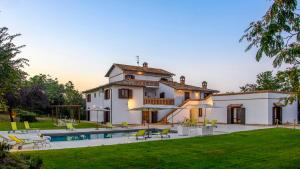 a large white house with a swimming pool at Villa Denise in Mancini