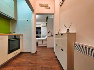 a kitchen with white cabinets and a large window at Parliament View Studio City Center - Pumo Properties in Bucharest +10 photos