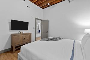 Un dormitorio blanco con una cama y un televisor de pantalla plana. en Stay in Style! Stunning River View - King Bed, en Saint Louis 3 fotos más