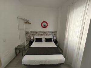 a bedroom with a bed and a clock on the wall at Apartamento Pepote in Málaga