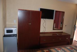 un grande mobile in legno con forno a microonde e televisore di Mount Laurel Motel a Hazleton