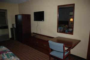 una camera d'albergo con scrivania, letto e specchio di Mount Laurel Motel a Hazleton Altre 13 foto