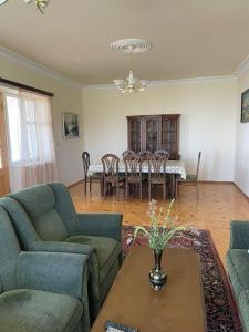 a living room with two couches and a table and chairs at Lernarot Guest House in Lernarot