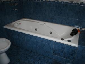 a bath tub in a blue tiled bathroom with a toilet at Bungalows Solares de Colón in Colón +9 photos