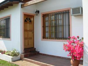 a house with a door and flowers in a vase at Bungalows Solares de Colón in Colón
