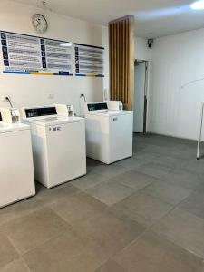 Una habitación con arandelas blancas y un reloj en la pared. en DEPARTAMENTO MODERNO Y COMODO CERCA A MOVISTAR ARENA Y FANTASILANDIA, en Santiago 22 fotos más