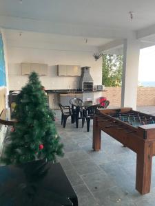 a living room with a christmas tree and a ping pong table at Suites mirante da Enseada in Guarujá