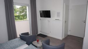 a living room with a couch and a tv and a window at Gästehaus Mira in Winterberg