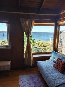 ein Schlafzimmer mit einem Bett und einem großen Fenster in der Unterkunft Cabaña Arte Patagonia in Puyehue