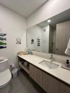 a bathroom with a sink and a toilet and a mirror at Luxury suite 10th floor near the beach in Santa Marta