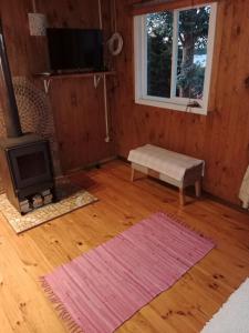 ein Wohnzimmer mit Kamin und Fernseher in der Unterkunft Cabaña Arte Patagonia in Puyehue