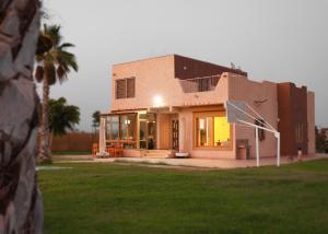 a house with a palm tree in front of it at Peaceful Family Villa on a Farm with Private Pool and Stunning Mountain Views in Agadir