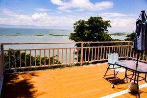 une terrasse en bois avec un parasol, une table et une chaise dans l'établissement Serenity Mezcala - Abitare, 