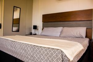 a bedroom with a large bed with a wooden headboard at Serenity Mezcala - Abitare in Isla de Mezcala