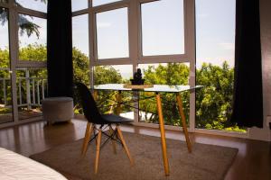 a table and a chair in a room with windows at Serenity Mezcala - Abitare in Isla de Mezcala +12 photos