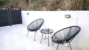 deux chaises et une table en verre sur une terrasse dans l'établissement Sueno de luz Corfu, à Áfra