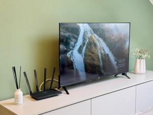a flat screen tv sitting on top of a white cabinet at Salvia 2kk Hodonín in Hodonín