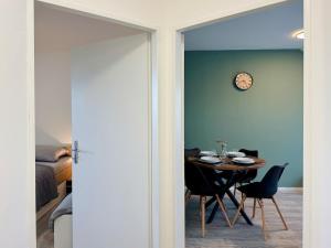 a dining room with a table and a clock on the wall at Salvia 2kk Hodonín in Hodonín +11 photos