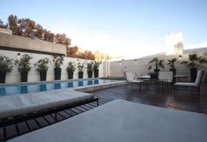 a patio with a pool and tables and chairs at Lujoso Departamento en Edificio de 1º nivel in Mendoza