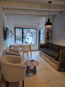 ein Wohnzimmer mit Sofa und Tisch in der Unterkunft Para quedarse - SalePatagonia in San Martín de los Andes