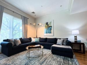 a living room with a blue couch and a table at Modern Townhome,boston Vacation,2 Bath,pkg,deck in Brookline