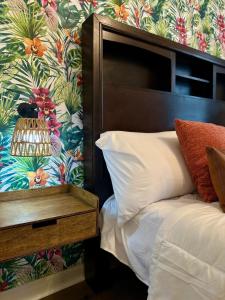 Un dormitorio con una cama con papel pintado floral. en Tampa Jungalow- Pool Oasis, en Tampa