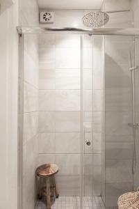 a shower stall with a stool in a bathroom at Modern och ljus lägenhet  +11 photos