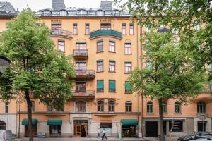 a large yellow building with trees in front of it at Modern och ljus lägenhet 