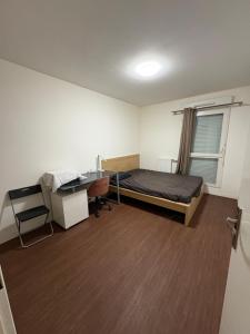 a bedroom with a bed and a desk in it at Bon77 in Noisiel +3 photos