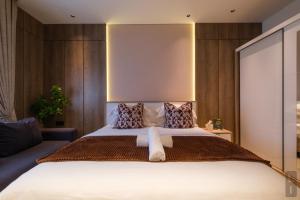 a bedroom with a large bed and a couch at Bluewaters, Labone in Accra