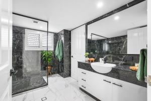 un baño con lavabo y ducha en Oceanfront Luxe 3BR, en Bargara 23 fotos más