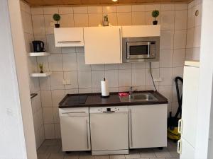a small kitchen with a sink and a microwave at Steffies Apartment two in Idstein