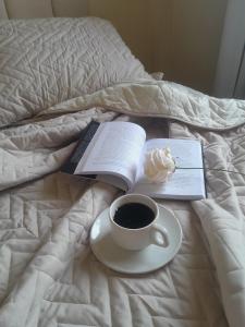 a book and a cup of coffee on a bed at Central 2 quartos WIFI Próximo shopping JL e terminal rodoviário in Cascavel