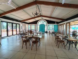 a dining room with tables and chairs and windows at HOTEL XIADANI Restaurante, Temazcal & Spa in Tlaxcala de Xicohténcatl
