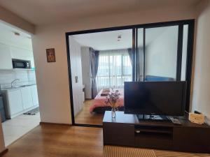 a living room with a television and a bedroom at centrio Condominium 8159 in Ban Rangeng