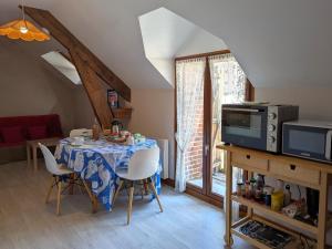 a dining room with a table and a microwave at Chambre d'hôtes avec petit-déjeuner inclus à Gidy - FR-1-590-452 in Gidy