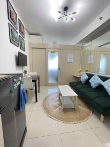 Una sala de estar con un sofá verde y una mesa. en Sea Residence Tower A by Stave, en Manila
