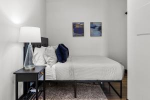 a bedroom with a bed and a table with a lamp at Riverfront Studio - Walk to Arch, Casino and Conventions in Minutes in Saint Louis