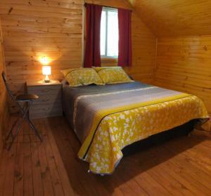 a bedroom with a bed in a wooden cabin at Cabaña Nido de Aguilas, Vilches Alto, San Clemente, Maule in San Clemente