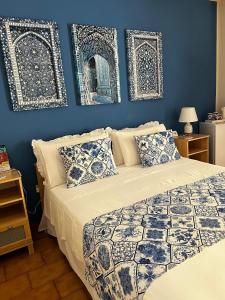 a bedroom with a bed with blue walls and two pictures at CASA DEL SOLE Accomodation in Tropea